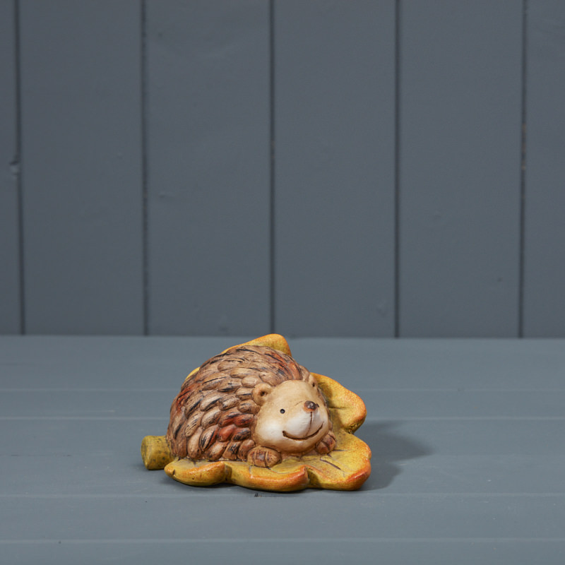 Ceramic Hedgehog laying on a leaf 